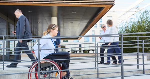 Woman in wheelchair using ramp to enter business